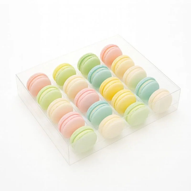 Pastel-colored macarons in a clear box on a white background Main image