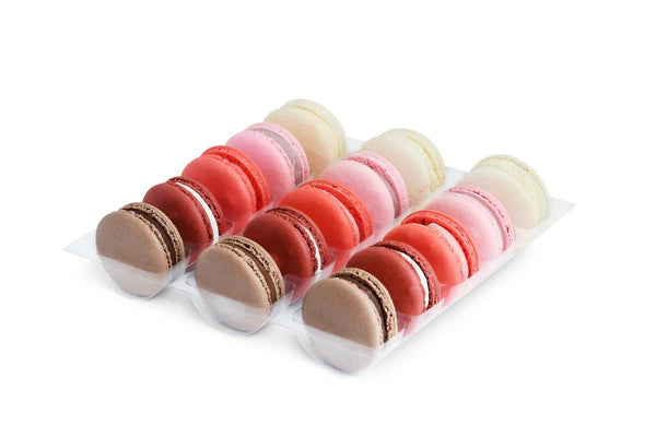 Assorted macarons in a clear plastic container on a white background Main image
